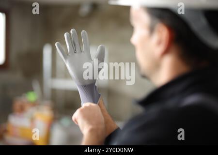 Close up of a construction worker putting protection gloves before work Stock Photo