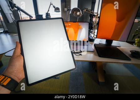 hand holding empty screen tablet mockup office interior Stock Photo