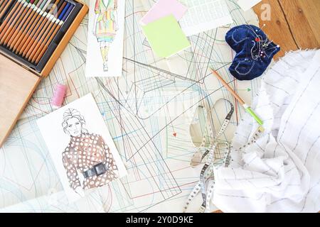 Table of the tailor with fabric, sketches and sewing equipment. Fashion and dressmaking concept banner Stock Photo