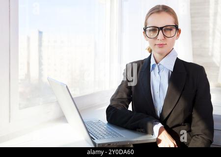 Young pretty business woman wearing eyeglasses with notebook in the office Stock Photo