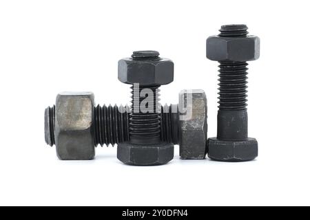 Orderly arrangement of dark-colored metal of hex bolts and nuts include long and shorter parts, placed against a clean, white background Stock Photo