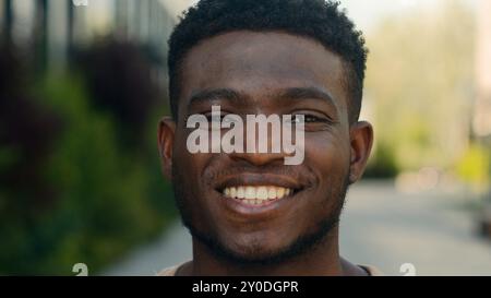 Closeup headshot African American cheerful positive happy smiling guy ethnic biracial man millennial male smile toothy white teeth dental service Stock Photo