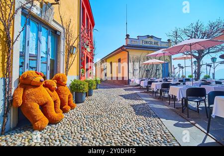 Via al Castello on San Vigilio Hill with vintage houses, outdoor dining and the station of Bergamo - San Vigilio funicular in background, Bergamo, Lom Stock Photo