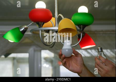 the concept of replacing an incandescent lamp with an LED one. Stock Photo
