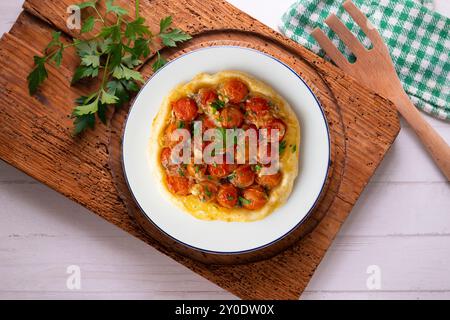 Savory tarte tatin with cherry tomatoes. Top view table with christmas decoration. Stock Photo