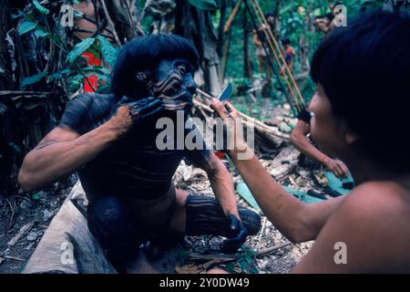 Yanomami Indian man having his face painted in preparation for a feast. In the Amazonian Forest in southern Venezuela. Stock Photo