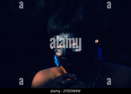 Yanomami Indian man with his fave painted black and with feather ear decorations, ready for a feast. In the Amazonian Forest in southern Venezuela. Stock Photo