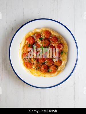 Savory tarte tatin with cherry tomatoes. Top view table with christmas decoration. Stock Photo