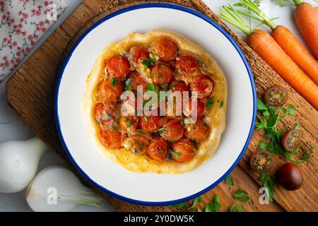 Savory tarte tatin with cherry tomatoes. Top view table with christmas decoration. Stock Photo