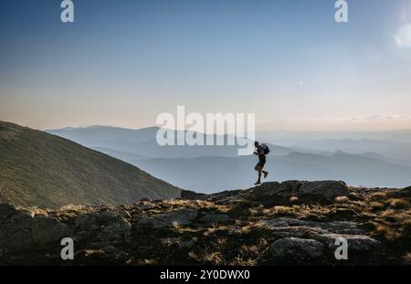 trail runner jumps from rocks on Appalachian Trail, New Hampshire Stock Photo