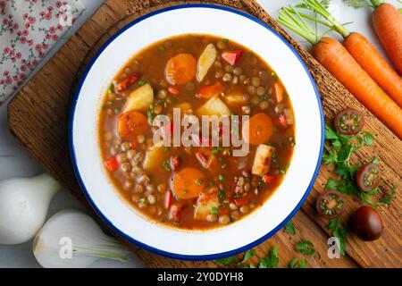 Spicy stewed lentils with vegetables and potatoes. Top view table with  decoration. Stock Photo