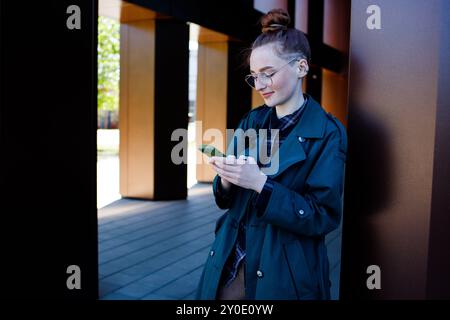 Student girl in eyeglasses writing message on mobile phone Stock Photo