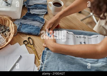 A woman joyfully upcycles garments on a sunny afternoon. Stock Photo