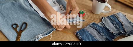 A woman skills her creativity by transforming old garments into new designs. Stock Photo