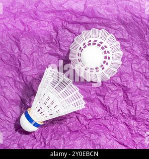 Two badminton shuttlecocks on crumpled purple paper Stock Photo