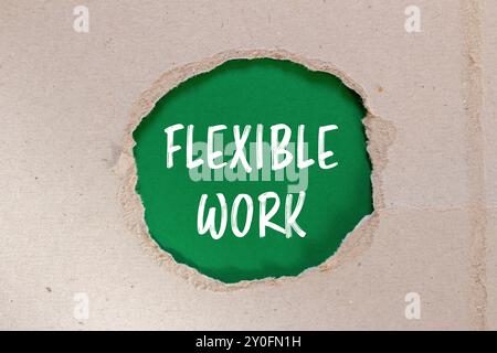 Flexible work message written on ripped torn paper with green background. Conceptual flexible work symbol. Copy space. Stock Photo