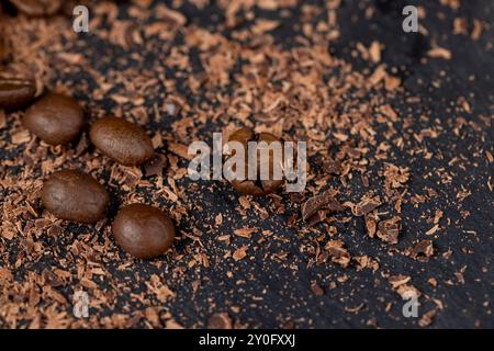 Roasted coffee beans lie together with chocolate crumbled into small pieces, fragrant coffee together with chocolate crumbs Stock Photo