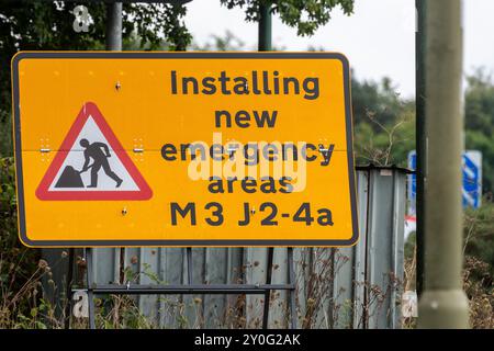 September 2024. A programme to create additional emergency areas on sections of all lane running (ALR) motorway across the country is underway. These motorways are commonly called Smart Motorways. Pictured: a road sign stating Installing new emergency areas M3 J2-4a near Farnborough, Hampshire, England, UK. Stock Photo