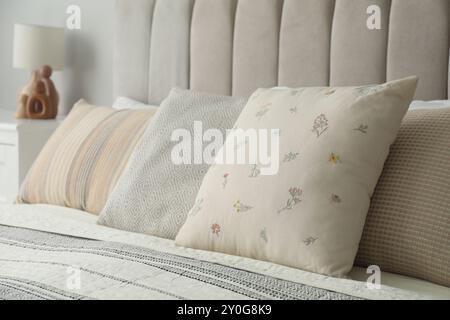 Different color pillows on bed in bedroom, closeup Stock Photo