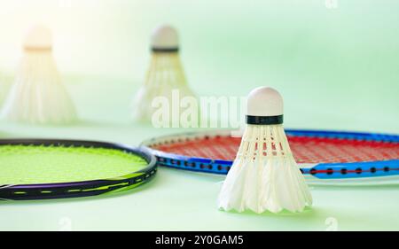 White badminton shuttlecocks and badminton rackets on green background Stock Photo