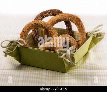 Green cloth bread  basket with round Koulouri Greek breads on green checked tablecloth Stock Photo