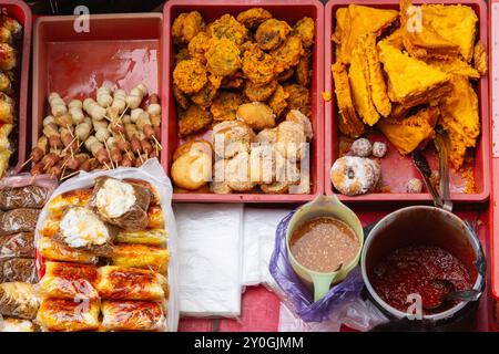 Assorted Malaysian street food selection featuring skewers, kuih and fried treats. Stock Photo