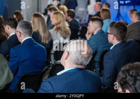 Business professionals engaged in a corporate conference with a diverse group of attendees. Focus on networking and presentations. Stock Photo