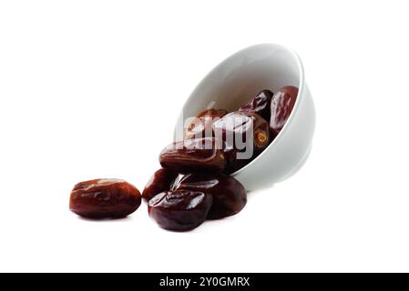 Dried dates from white bowl on white background. Copy space. Stock Photo