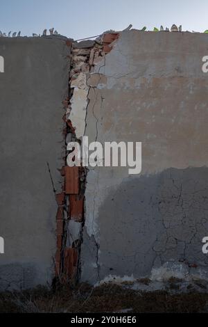 Concrete fence with a broken and repaired part. Shards on the edge. Blue sky. Protection of a resort. Djerba, Tunisia, Africa. Stock Photo