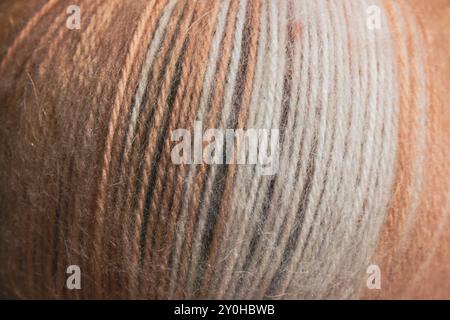 Multi coloured yarn ball close up. Warm yarn background. Bright knitting yarn. Knitting hobby. Handicraft concept. Wool and alpaca wool threads. Stock Photo