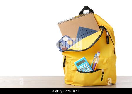 Backpack with different school stationery on wooden table against white background, space for text Stock Photo