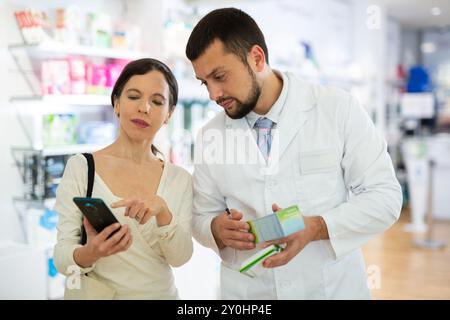 Male pharmacist consulting woman customer in drugstore Stock Photo