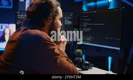 Cheerful software technician feeling satisfied after removing all bugs while coding on computer, close up. Smiling IT expert looking at screen, happy after solving script errors, camera B Stock Photo