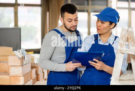 Woman and man repairers talking about documentation Stock Photo