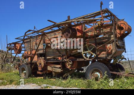 Rusty old combine harvester on green fields under blue sky, wrecked vehicle, Crete, Greek Islands, Greece, Europe Stock Photo