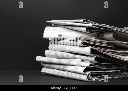Stack of newspapers in different languages on black background Stock Photo