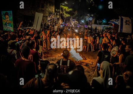 Protestors gather around a bonfire during a protest in Jerusalem following the funeral of Hersh Goldberg Polin Monday, Sept 2 2024. Tens of thousands of people have rallied across Israel for a second day after the bodies of Carmel Gat, Eden Yerushalmi, Hersh Goldberg-Polin, Alexander Lobanov, Almog Sarusi and Master Sgt Ori Danino,  were rescued from Gaza.  Protesters calling on PM Benjamin Netanyahu and his government to reach a deal to secure the release of the remaining hostages taken by Hamas during the 7 October attacks. Photo by Eyal Warshavsky. Stock Photo