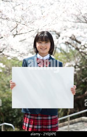 School girl holding a message board and cherry trees Stock Photo