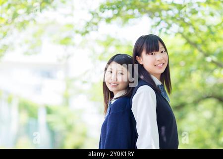Two Japanese high school girls standing back to back Stock Photo