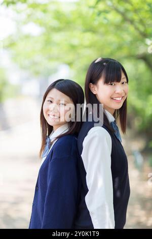 Two Japanese high school girls standing back to back Stock Photo