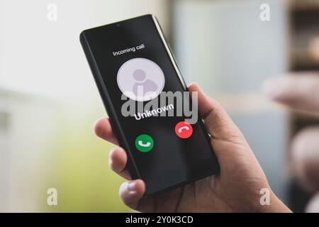 Unknown number calling in the middle of morning. Phone call from stranger. Person holding mobile and smartphone home. Unknown caller. Stock Photo