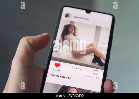 Close-up Of Man Using Social Network On Digital smarphone. All the graphics on the screen are made up. Stock Photo