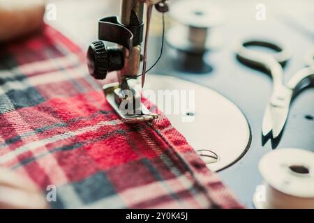 Woman hand sewn fabric pink repairs on old sewing machine. Sewing fabric on a sewing machine close-up Stock Photo