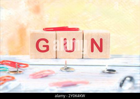 A word gun assembled from cubes on a yellow background Stock Photo