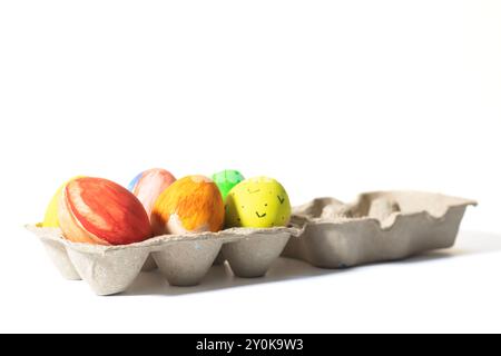 Colorful easter eggs in a carton isolated on white background. Closeup Stock Photo
