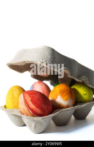 Colorful Easter eggs in a carton isolated on white background. Selective focus Stock Photo