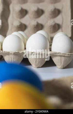 Eggs in a carton on a white background. Selective focus. Vertical shot Stock Photo