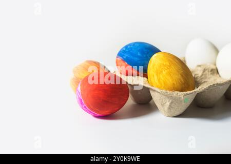 Colorful Easter eggs in egg carton isolated on white background. Closeup Stock Photo