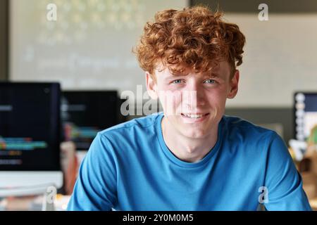 Smiling Student Sitting at Desk in School Stock Photo