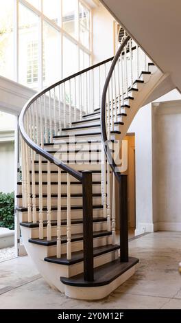 Elegant spiral staircase with wooden railings in modern home interior Stock Photo
